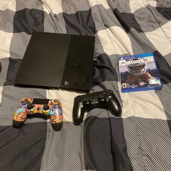 Black PS4 with two controllers and a madden 24 game